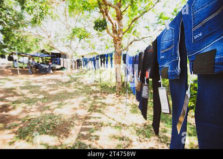 Jeans und andere Hosen hängen an einer Schlange zum Verkauf am Straßenrand in der Nähe von Tangalle in Sri Lanka Stockfoto