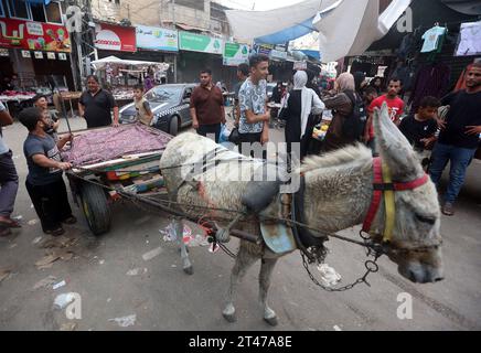 Gaza, Palästina. Oktober 2023. Die Palästinenser nutzen Tierkarren als Taxis, um zwischen Stadtteilen und Gebieten in der Stadt Khan Yunis zu fahren, da der Treibstoff in Khan Yunis ausfällt. Während der anhaltenden Kämpfe zwischen Israel und der palästinensischen Gruppe Hamas. Der Internetzugang und das Telefonnetz wurden am 28. Oktober vollständig über den Gazastreifen geschnitten, fast drei Wochen nachdem Israel mit der Bombardierung der Enklave begonnen hatte, nach einem bewaffneten Angriff von Hamas-Militanten, bei dem israelische Beamte mindestens 1.400 Menschen, meist Zivilisten, getötet haben. Quelle: SOPA Images Limited/Alamy Live News Stockfoto