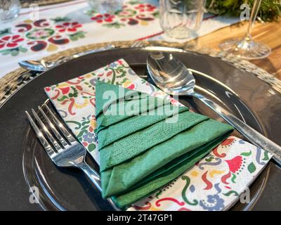 Tisch für Weihnachten oder Silvesterdinner. Grüne noelbaum-förmige gefaltete Serviette auf Tellern für weihnachten oder Neujahr. noel-Dekoration Stockfoto