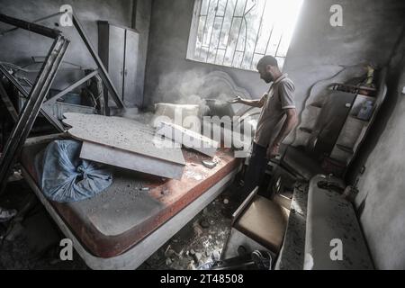 Al Bureij, Palästinensische Gebiete. Oktober 2023. Ein Palästinenser inspiziert ein beschädigtes Haus im Lager Al-Bureij nach israelischen Luftangriffen. Quelle: Mohammed Talatene/dpa/Alamy Live News Stockfoto