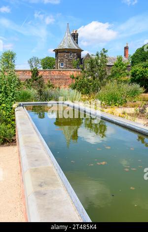 Das Garden Cottage spiegelt sich in einem Wasserspiel im Kitchen Garden in den RHS Bridgewater Gardens, Worsley, Salford, Greater Manchester, Großbritannien wider Stockfoto