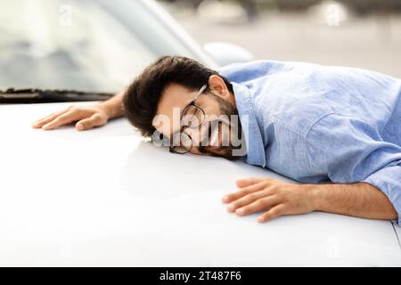 Ein glücklicher junger indianer hat ein neues Auto Stockfoto