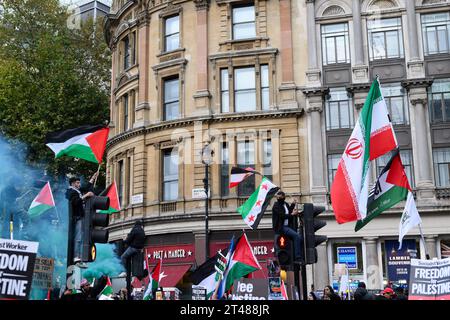 Demonstranten, die palästinensische Fahnen über der Ampel schwenken, rufen zum Waffenstillstand in Gaza auf, Trafalgar Square, London, Großbritannien. 28. Oktober 2023 Stockfoto