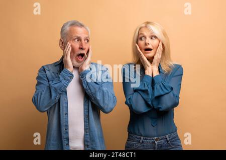 Schockierte ältere Männer und Frauen, die sich anschauen Stockfoto