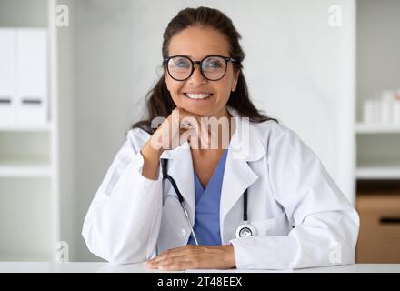 Fröhliche Reife Ärztin In Uniform Lächelt Vor Der Kamera Stockfoto