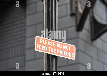 Ein Schild in einer Stadt lautet: Bitte füttere die Tauben nicht. Das Konzept der städtischen Schädlingsbekämpfung. Stockfoto