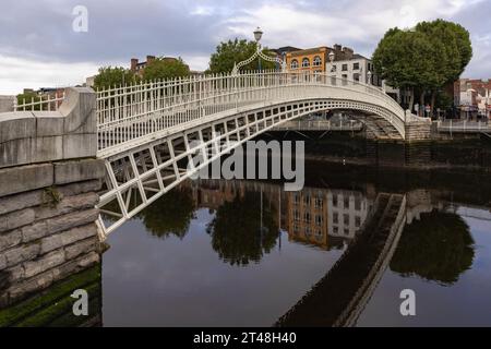 Die ha'Penny Bridge ist eine Fußgängerbrücke über den Fluss Liffey in Dublin, Irland, die für ihr schönes gusseisernes Design und ihren ikonischen Status bekannt ist. Stockfoto