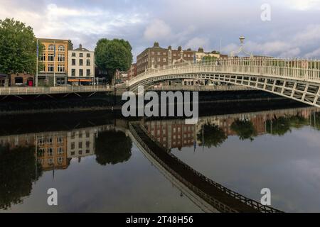 Die ha'Penny Bridge ist eine Fußgängerbrücke über den Fluss Liffey in Dublin, Irland, die für ihr schönes gusseisernes Design und ihren ikonischen Status bekannt ist. Stockfoto