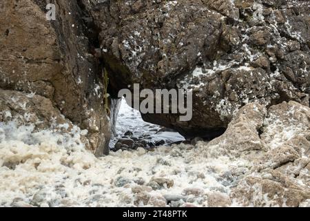 Wasser und Meeresschaum auf den Dolomitfelsen im Arches Provincial Park in Neufundland Stockfoto