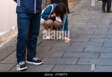 Seoul, Südkorea. Oktober 2023. Eine Frau berührt die Gasse, in der sich ein Menschenmassen-Mord im Unterhaltungsviertel von Itaewon, Seoul, befindet. Der Massen-Crush-Vorfall im Vergnügungsviertel Itaewon in Seoul während des Halloween-Festivals am 29. Oktober 2022, bei dem 159 Menschen getötet und 196 verletzt wurden. Quelle: SOPA Images Limited/Alamy Live News Stockfoto