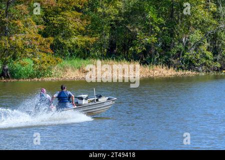LAKE FAUSSE POINTE STATE PARK, LA, USA - 25. OKTOBER 2023: Seitenansicht eines Paares in einem Boot, das durch das Wasser des Atchafalaya River Basin fährt Stockfoto