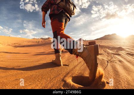 Nahaufnahme von Männerbeinen ist ein Spaziergang durch Sanddünen Stockfoto
