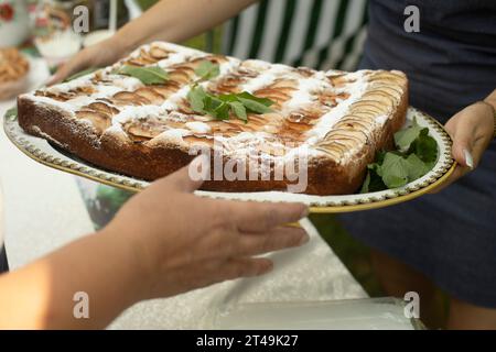 Apfelkuchen in den Händen. Leckeres Gebäck von meiner Großmutter. Süßes Essen. Volksbackrezept. Stockfoto