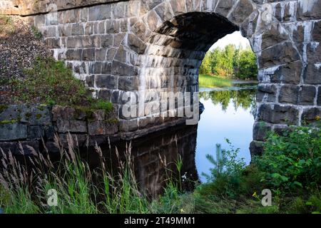 EISENBAHNBRÜCKENBOGEN, SEE, KAJAANI: Ein Eisenbahnbrückenbogen über einem See in Jormua im Sommer in der Region Kajaani in Mittelfinnland. Foto: Rob Watkins Stockfoto