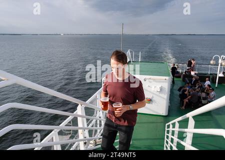 Ein Mann mit zwei Pints Bier auf einer Kreuzfahrtfähre, die Helsinki verlässt und auf einer Ostseekreuzfahrt zwischen Finnland, Åland und Stockholm in Schweden fährt. Stockfoto