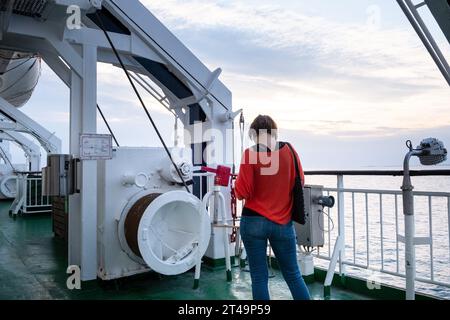 Eine stilvolle Frau betrachtet die nächtliche Sonne auf einer Ostseekreuzfahrt zwischen Helsinki Finnland, Åland und Stockholm in Schweden. Stockfoto