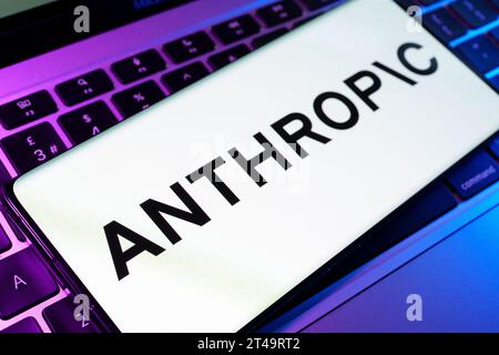 Das Logo des anthropischen KI-Forschungsunternehmens, das auf dem Smartphone zu sehen ist, wird auf dem Laptop platziert. Stafford, Vereinigtes Königreich, 29. Oktober 2023 Stockfoto