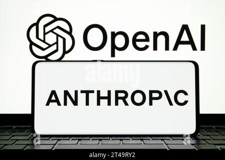 Das anthropische KI-Forschungsunternehmen Logo auf dem Smartphone und DAS OPENAI-Logo auf dem Hintergrund. Stafford, Vereinigtes Königreich, 29. Oktober 2023 Stockfoto