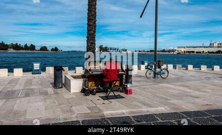 An der Küste in Brindisi, Italien, spielt ein Mann Klavier. Stockfoto