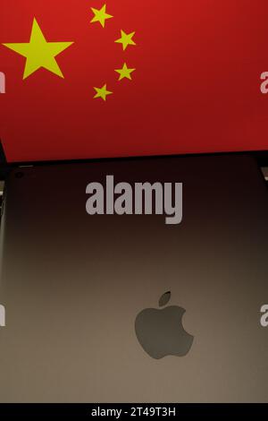 Apple-Logo auf dem iPad und unscharfe Flagge von China auf dem Hintergrund. Konzept. Stafford, Vereinigtes Königreich, 29. Oktober 2023 Stockfoto