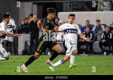 Der LAFC-Stürmer Cristian Olivera (25) wird von Vancouver Whitecaps-Mittelfeldspieler Andrés Cubas (20) im ersten Spiel der MLS Playoffs verteidigt Stockfoto