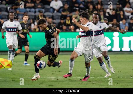 Der LAFC-Stürmer Cristian Olivera (25) wird von Vancouver Whitecaps-Mittelfeldspieler Alessandro Schöpf (8) im ersten Spiel der MLS-Playoffs verteidigt Stockfoto