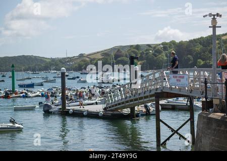 Salcombe Harbour, von Whitestrand an einem Sommertag mit blauem Himmel und weißen Wolken, mit Steg, verankerten Yachten und East Portlemouth im Hintergrund Stockfoto