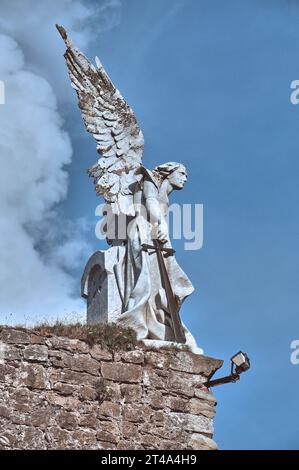 Eine eindrucksvolle Engelsstatue, die auf dem Comillas Cemetery bewacht und sowohl Gelassenheit als auch Wachsamkeit vermittelt Stockfoto