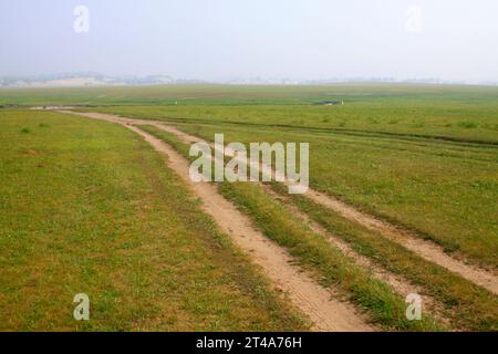 Unbefestigte Straße im WuLanBuTong Grasland, der autonomen Region der Inneren Mongolei, China. Stockfoto