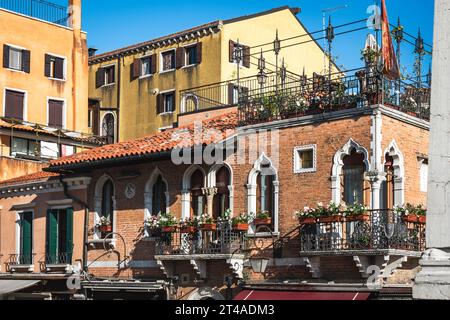 Charmantes Gebäude mit Topfpflanzen auf Balkonen und Dachterrasse in Venedig, Italien Stockfoto