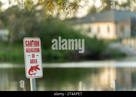 Warnschild über Alligator im Wasser im Florida Park. Vorsicht und Sicherheit beim Gehen in der Nähe des Ufers Stockfoto