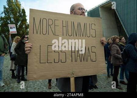 Ein Mann hält ein Schild mit der Aufschrift „More Hummus less Hamas“ während einer Mahnwache in Warschau, Polen am 29. Oktober 2023. Mehrere hundert Menschen nahmen an einer Mahnwache zu Ehren der Opfer des Angriffs der Hamas vom 7. Oktober Teil, der Hunderte von Menschenleben kostete. Die Mahnwache fand im POLIN Museum für die Geschichte der polnischen Juden in der Nähe des Warschauer Ghettoaufstandes statt. Mehrere hundert Menschen nahmen an einer Mahnwache zu Ehren der Opfer des Angriffs der Hamas vom 7. Oktober Teil, der Hunderte von Menschenleben kostete. Die Mahnwache fand im POLIN Museum für die Geschichte der polnischen Juden in der Nähe des Warschauer Ghettoaufstandes statt. Ein Gebet wurde im gehalten Stockfoto