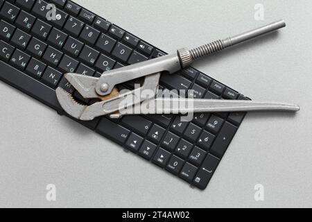 Der verstellbare Schraubenschlüssel befindet sich auf der Tastatur. Konzept zur Wartung und Reparatur von EDV-Geräten. Stockfoto