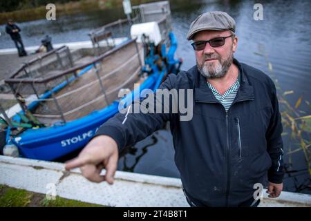 Stolpe, Deutschland. Oktober 2023. Der Fährmann Ulf Radicke steht am Pier der kleinen Passagierfähre über die Peene und wartet auf Passagiere. Von März bis Oktober können Wanderer oder Radfahrer die fast 100 Meter über den Fluss überqueren. Die nun zu Ende gehende Saison könnte jedoch ihre letzte sein – die einzige Fußgängerfähre zwischen Anklam und Jarmen ist wegen fehlender finanzieller Unterstützung durch den Bezirk von der Schließung bedroht. Die Gemeinde hat daher eine Kampagne zur Rettung der Fähre gestartet. Jetzt werden 2.000 Unterschriften gesammelt, bis der Bezirk Credit: dpa/Alamy Live News Stockfoto