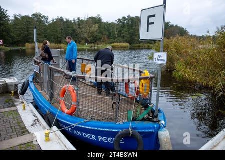 Stolpe, Deutschland. Oktober 2023. Der Fährmann Ulf Radicke nimmt Passagiere auf der kleinen Passagierfähre über die Peene mit. Von März bis Oktober können Wanderer oder Radfahrer die fast 100 Meter über den Fluss überqueren. Die nun zu Ende gehende Saison könnte jedoch ihre letzte sein – die einzige Fußgängerfähre zwischen Anklam und Jarmen ist wegen fehlender finanzieller Unterstützung durch den Bezirk von der Schließung bedroht. Die Gemeinde hat daher eine Kampagne zur Rettung der Fähre gestartet. Jetzt werden 2.000 Unterschriften bis zur bezirksratssitzung Mitte November gesammelt. Credit: dpa/Alamy Live News Stockfoto