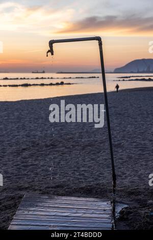 Tropfende Dusche bei Sonnenuntergang am Strand, Marina di Massa, Toskana, Italien Stockfoto