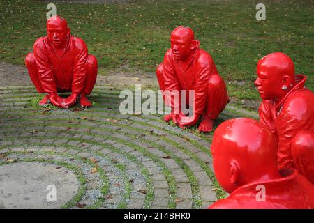 Skulpturentreffen von Wang Shugang 2013, Skulpturengruppe, rot, Figuren, Kreis, sitzen, Männer, Chinesen, chinesische Mönche, kniend, Kopf, zurück Stockfoto