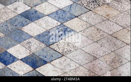 Horizontaler oder vertikaler Hintergrund mit Bodenfliesen aus Naturgranit. Hintergrund aus Granit mit Vintage-Rhomboidal-Fliesen in Blau und Grau. Poli Stockfoto