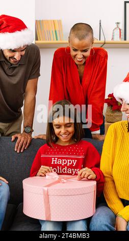 Junge Familie, die zusammen weihnachtsgeschenke zu Hause eröffnet Stockfoto