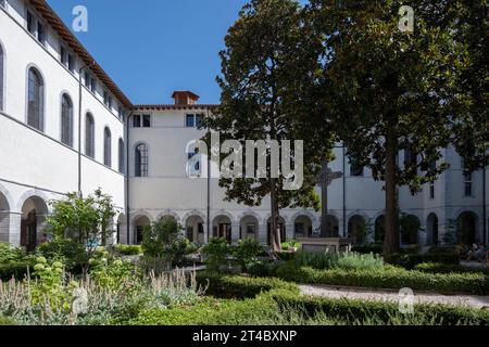 Frankreich, Lyon, 26. Juli 2019. Kreuz umgeben von zwei Magnolien in der Mitte eines Gartens im Innenhof des großen Klosters des Hotels Dieu de Stockfoto