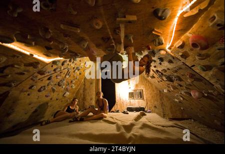 Eine Frau, die auf eine selbstgemachte Kletterwand klettert, Moab, Utah. Stockfoto