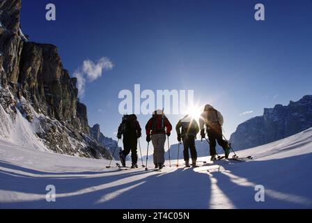 vier Skifahrer durchqueren über gefrorenen Fjord in der Nähe von Baffin Island, Kanada Stockfoto