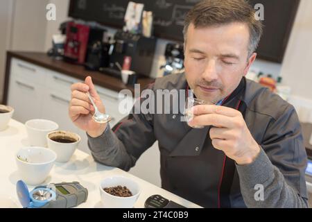 Hübscher Barista-Mann, der lächelt und Kaffeebohnen hält Stockfoto