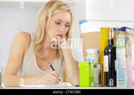 Eine Frau auf der Lebensmittelliste Stockfoto