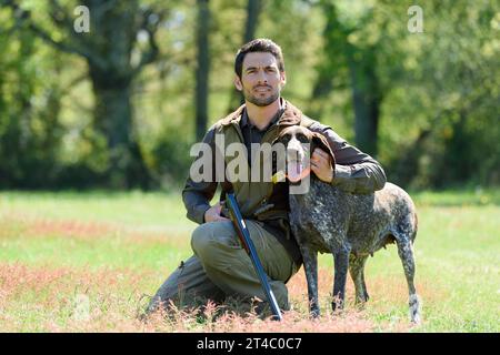 hunter hält eine Waffe, die von seinem Hund gehockt wurde Stockfoto