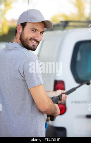 Ein Mann wäscht seinen weißen Van Stockfoto