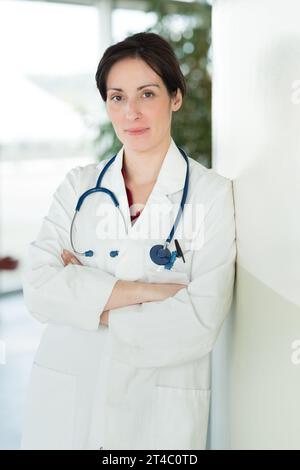 Ärztin lehnt sich an die Wand Stockfoto