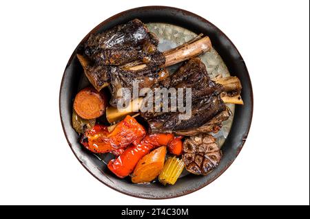 Hausgemachte geschmorte Lammschnecken mit Sauce und Kräutern in einem Stahltablett. Isoliert auf weißem Hintergrund Stockfoto