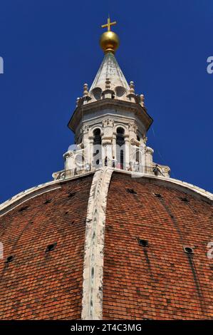 Weißer Marmorturm oder Laterne auf dem Gipfel der achteckigen Kuppel der Kathedrale von Florenz in der Toskana, Italien. Die Aussichtsplattform am Fuß des Turms befindet sich 90 Meter (295 Fuß) über dem Boden und bietet einen Panoramablick auf die Stadt und die umliegenden toskanischen Hügel. Die Laterne wird von einer goldenen Kugel und einem Kreuz gekrönt: Die ursprüngliche Kugel von Andrea del Verocchio (1435–1488) wurde 1471 installiert; die aktuelle Kugel ist eine Rekonstruktion aus dem 16. Jahrhundert. Stockfoto