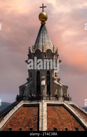 Weißer Marmorturm, gekrönt von einer goldenen Kugel und einem goldenen Kreuz, auf dem Gipfel der Kuppel der Kathedrale von Florenz in der Toskana, Italien. Die Aussichtsplattform am Fuß des Turms befindet sich 90 Meter (295 Fuß) über dem Boden und bietet einen Panoramablick auf die Stadt und die umliegenden toskanischen Hügel. Stockfoto